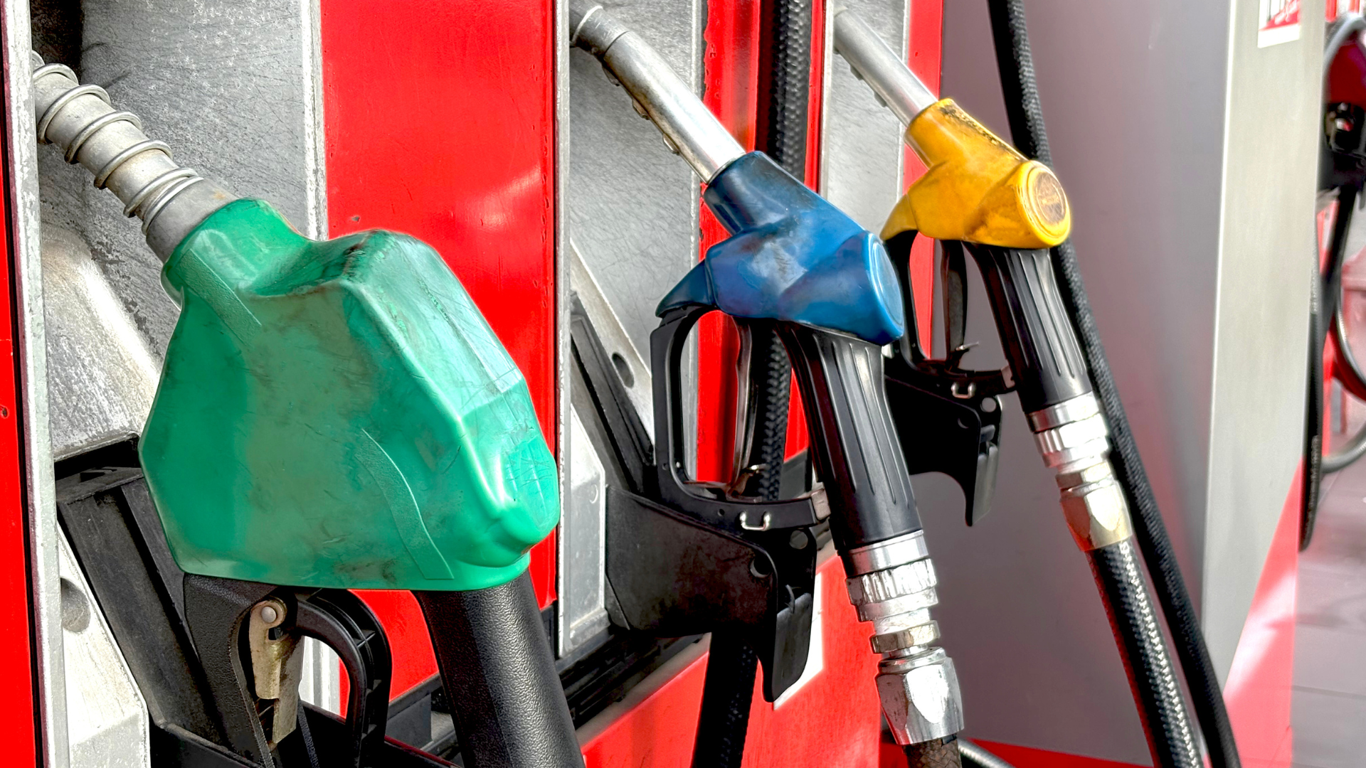 High-resolution photo of fuel nozzles in various colors at a gas station, showcasing fueling infrastructure and safety features.